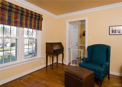 The living room has hardwood flooring, crown moldi