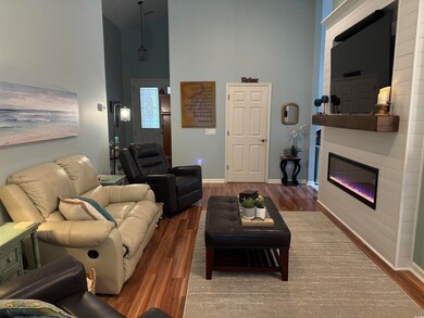 Living room featuring a glass covered fireplace, b