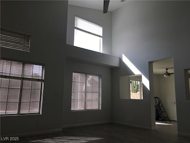 Unfurnished living room featuring ceiling fan, a towering ceiling, and dark wood-type flooring
