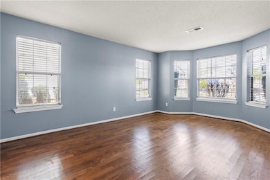 Unfurnished room featuring visible vents, baseboar