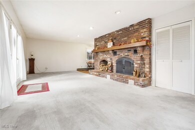 Living room featuring a brick fireplace, carpet, and recessed lighting
