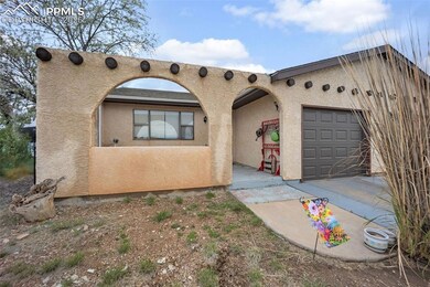 Pueblo-style house featuring an attached garage an