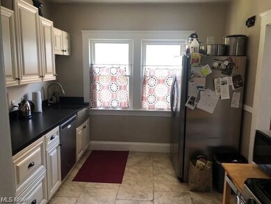 Kitchen featuring sink, stainless steel refrigerator, dishwasher, and light tile floors