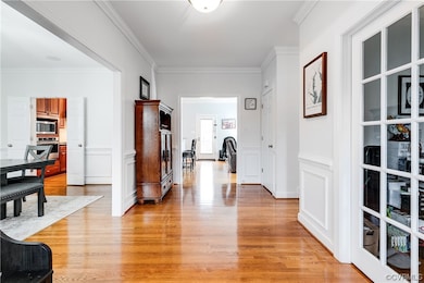 Corridor with crown molding and hardwood wood floo