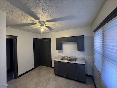 Kitchen featuring light countertops, a textured ceiling, and ceiling fan