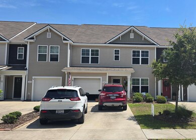 View of property featuring driveway, an attached g