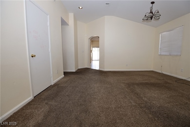 Empty room with arched walkways, carpet floors, a