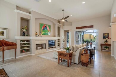 Living area with a tiled fireplace, built in shelves, light tile patterned flooring, recessed lighting, and a ceiling fan