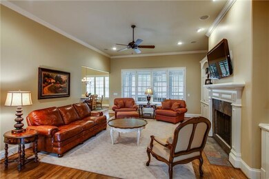 Spacious living room, boasting custom builtins, gas fireplace & plantation shutters.