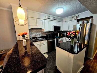 Kitchen with white cabinets, appliances with stain
