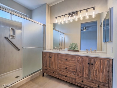 Bathroom featuring ceiling fan, a shower stall, do