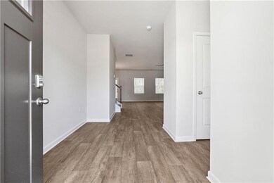 Hallway with wood finished floors, baseboards, and