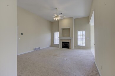Unfurnished living room with light carpet, a tiled