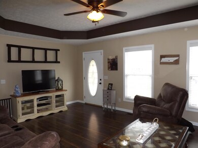 Great room with trey ceiling, laminate floor & ceiling fan.
