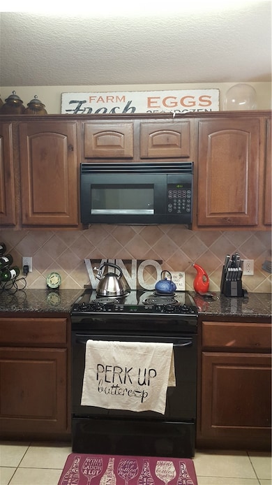 Kitchen with tasteful backsplash, light tile patte