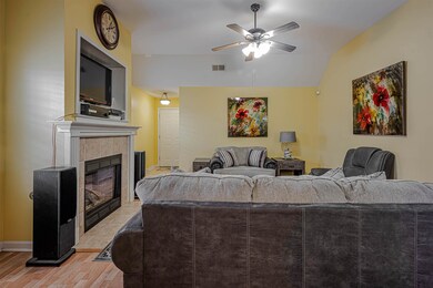 Living room featuring vaulted ceiling, a tile fire