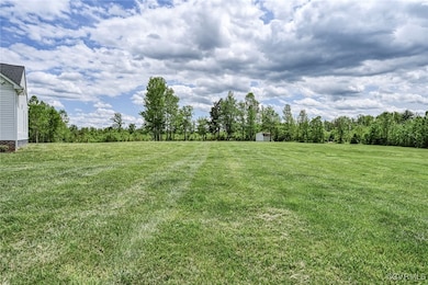 View of grassy yard featuring a storage unit and a