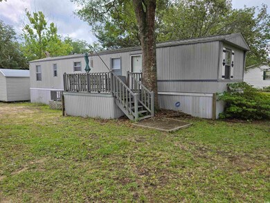 Back of house featuring a yard, a deck, and an outdoor structure