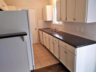 Kitchen featuring freestanding refrigerator, dark