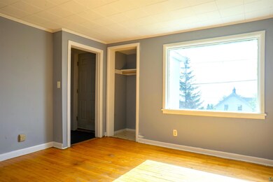 Unfurnished bedroom featuring a closet, crown mold