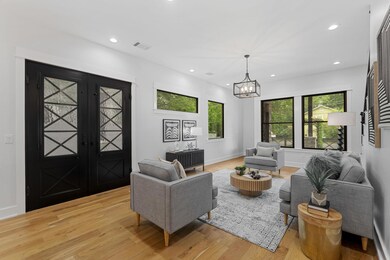 Living room with light wood finished floors, a ch