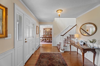Enter a gracious foyer with turned custom staircase