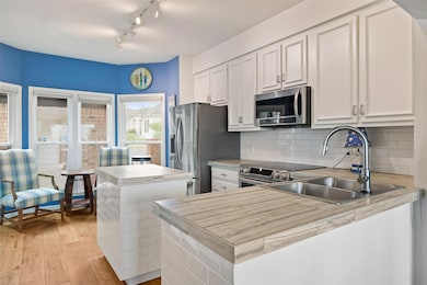 Kitchen featuring a sink, white cabinetry, tastef