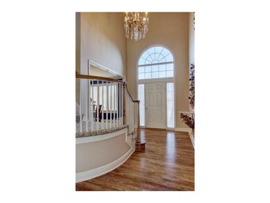 Grand 2 sty entry w/ curved staircase covered in d