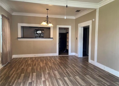 Spare room with wood finished floors and crown mo