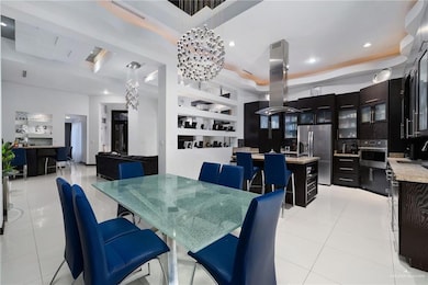 Dining area with light tile patterned floors, a tray ceiling, and recessed lighting
