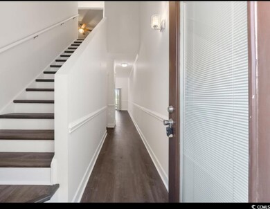 Stairway with wood finished floors and baseboards