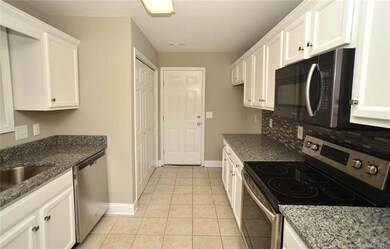 Updated kitchen offers granite countertops, tile b