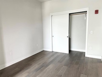 Unfurnished bedroom with dark wood finished floor