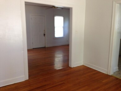 Corridor featuring dark wood-type flooring and baseboards