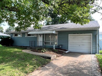 Concrete driveway leading into the oversized single car garage.