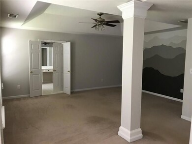 Basement with a ceiling fan and carpet
