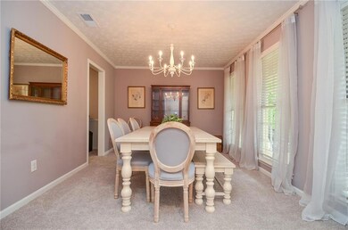 Dining room with light colored carpet, ornamental 