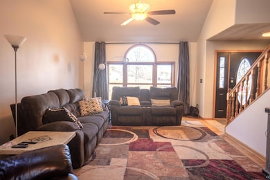 Living area featuring lofted ceiling, stairs, and 