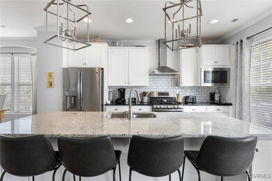Kitchen featuring wall chimney range hood, stainle