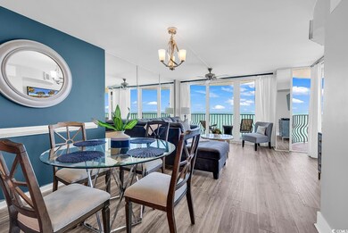 Dining space with ceiling fan, expansive windows, wood finished floors, and a chandelier
