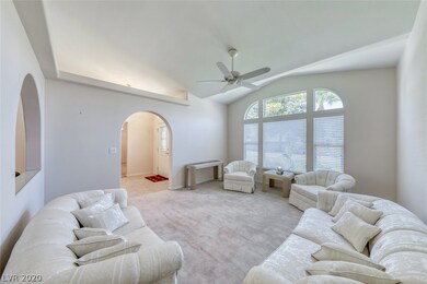 Formal living room with large windows, vaulted cei