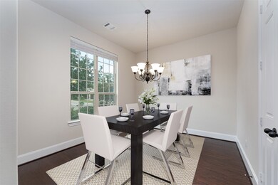 Dine in style in this beautiful formal dining room, featuring incredible wood floors, a gorgeous chandelier, and plenty of natural light through the large window with privacy blinds!