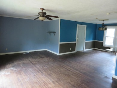 Empty room featuring ornamental molding, dark hard