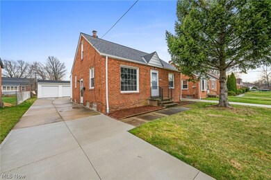View of front facade featuring a garage and a front lawn