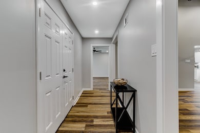 Hallway featuring baseboards, dark wood-style floo