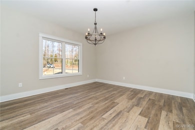 Spare room featuring baseboards, a notable chandel