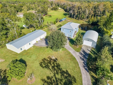 Aerial view of all buildings, stocked pond, garden area and chicken coop.