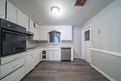Kitchen with a textured ceiling, sink, black appli
