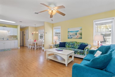 Living area with ceiling fan with notable chandeli