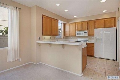 Sunny kitchen with wood cabinetry and breakfast ba